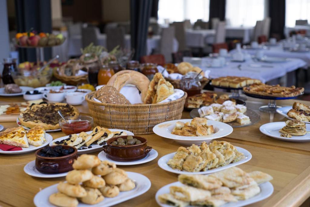una mesa llena de platos de comida en una mesa en Aigai Hotel, en Édessa