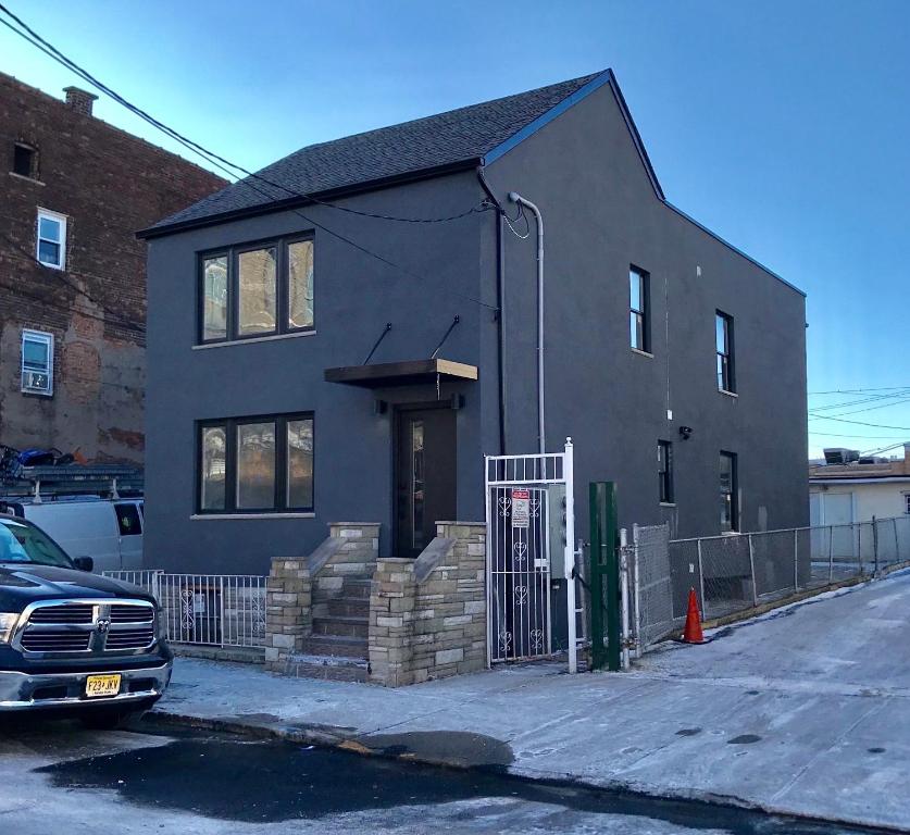 a black house with a gate in front of it at Modern GuestHouse Ironbound Newark with KITCHEN-FastTrainToNYC-OneStopToAirport in Newark