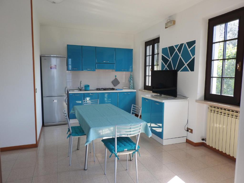 eine Küche mit blauen Schränken und einem Tisch mit Stühlen in der Unterkunft New Piccolo Residence in Malcesine