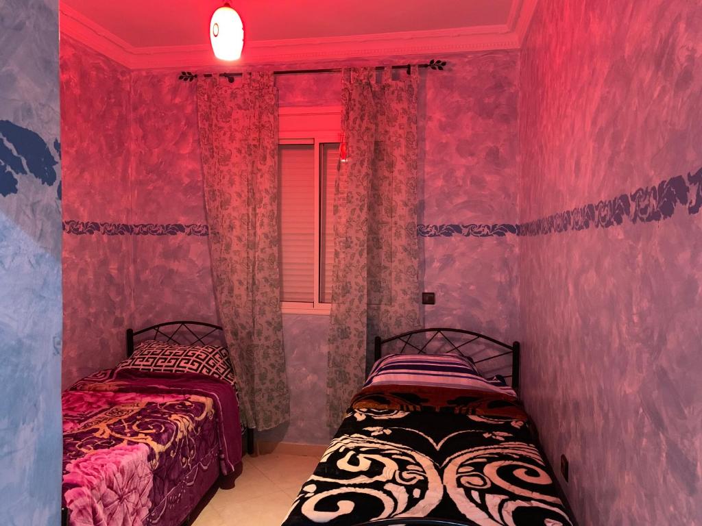 2 camas en una habitación con paredes rosas en Agadir Holiday Apartment en Agadir