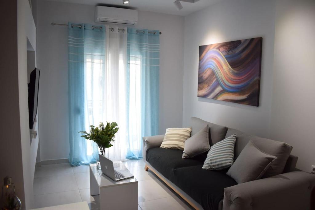 a living room with a couch and a painting on the wall at Central Luxury Apartment in Thessaloniki in Thessaloniki