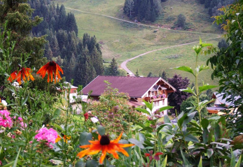 a house on a hill with flowers in the foreground at Apartmenthaus Kristall in Wagrain