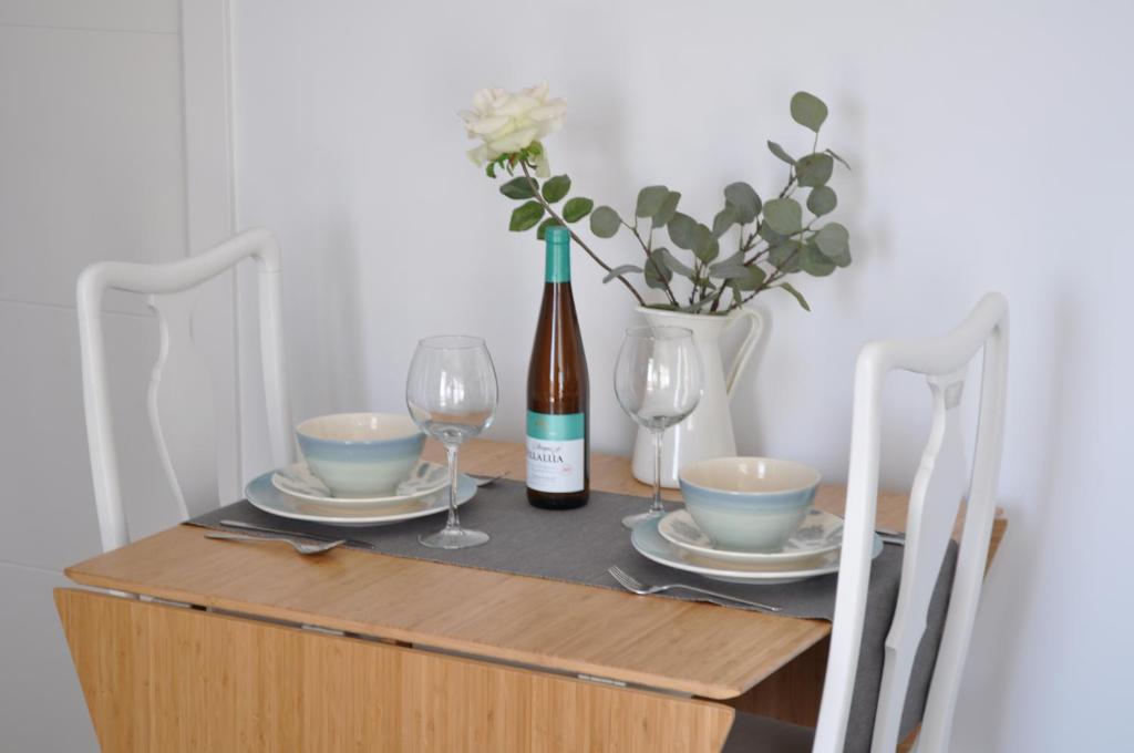 a table with a bottle of wine and two glasses at Apartamentos en Paseo Maritimo in El Rompido
