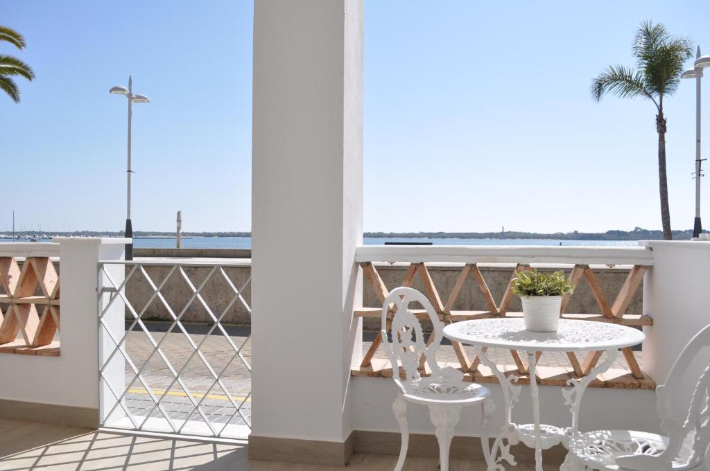 a balcony with a table and chairs and a view of the ocean at Apartamentos en Paseo Maritimo in El Rompido