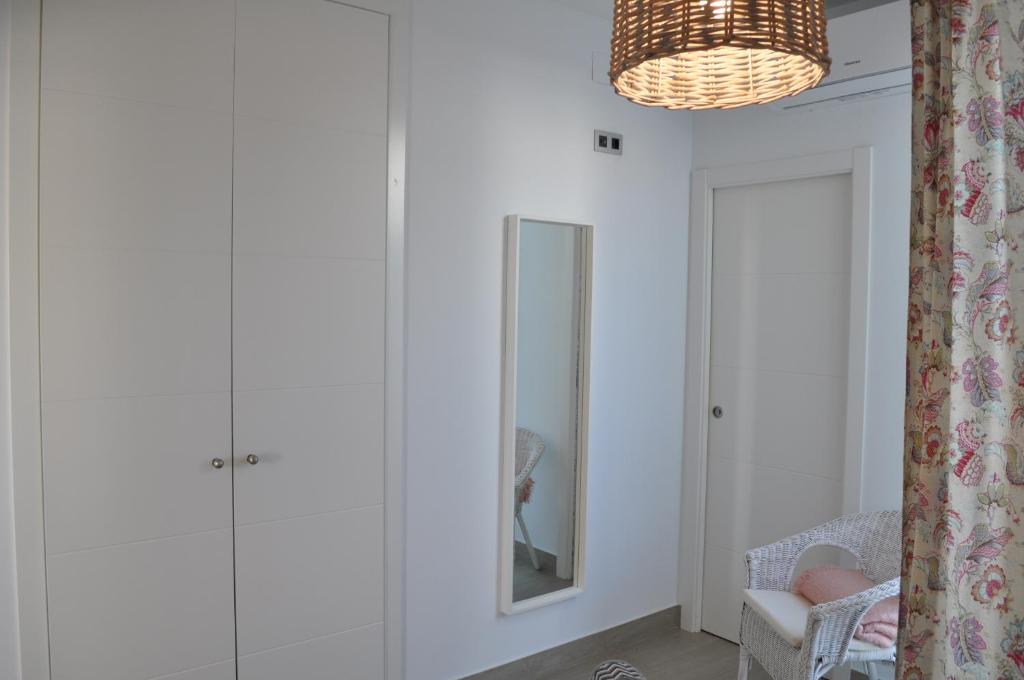 a living room with a mirror and a chair at Apartamentos en Paseo Maritimo in El Rompido