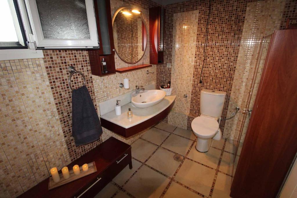 łazienka z umywalką i toaletą w obiekcie Natasa’s home Agios Ioannis Karousades w Korfu