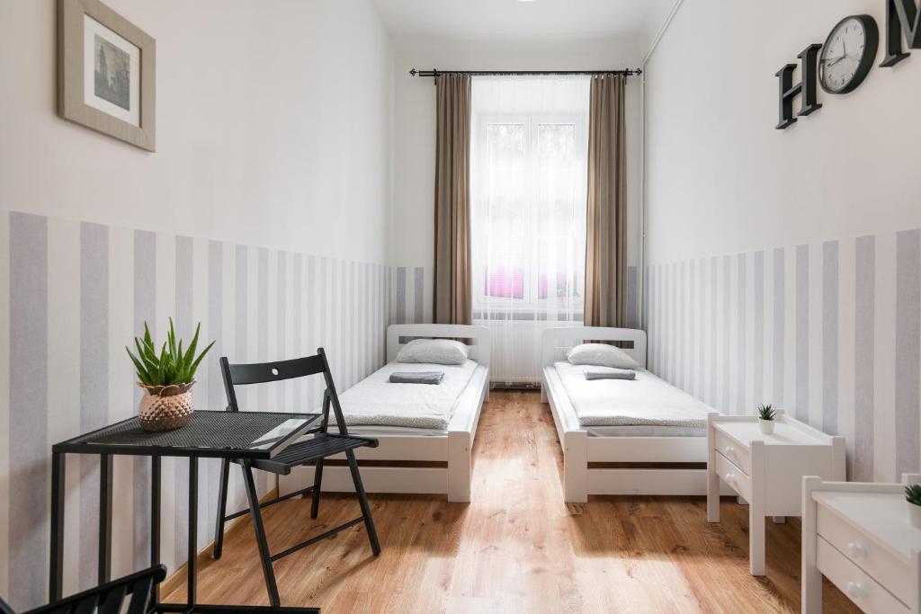 Cette petite chambre comprend deux lits et une table. dans l'établissement XXL Apartment Old Town 24 h - check in, Wi-Fi, à Cracovie