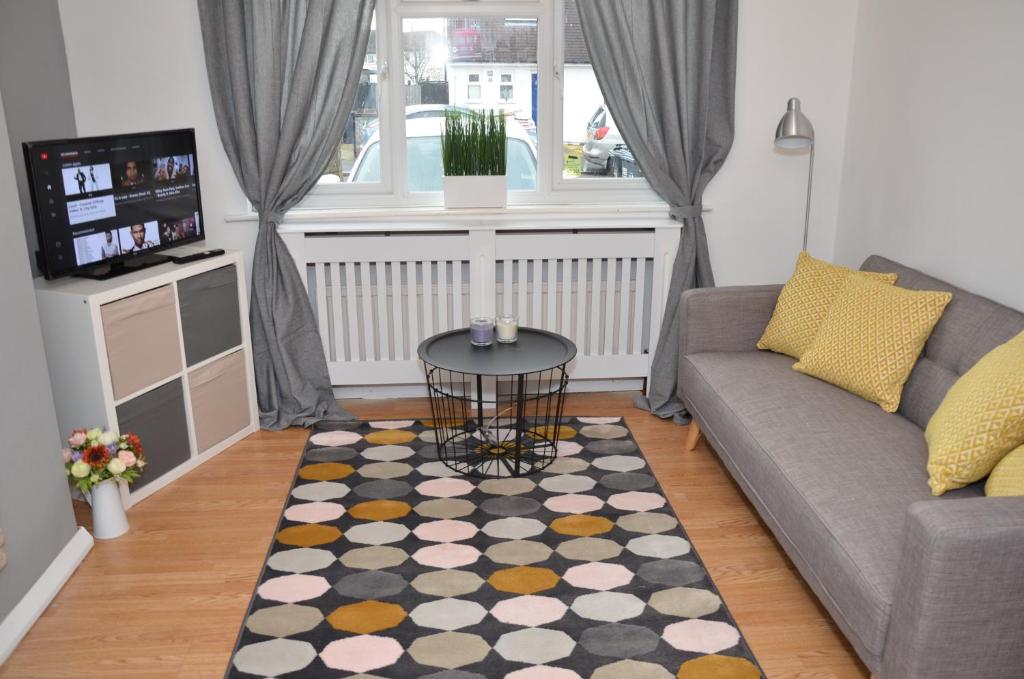 a living room with a couch and a table at Croydon apartment with parking in London