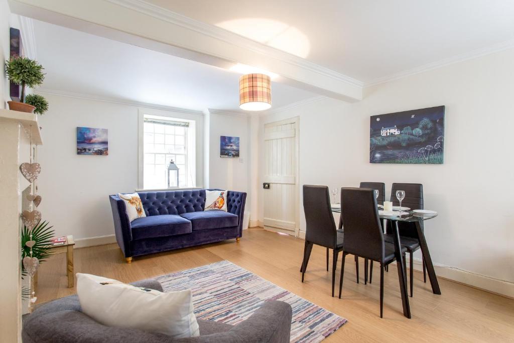 a living room with a blue couch and a table at Charming Apartment in the Old Town in Edinburgh