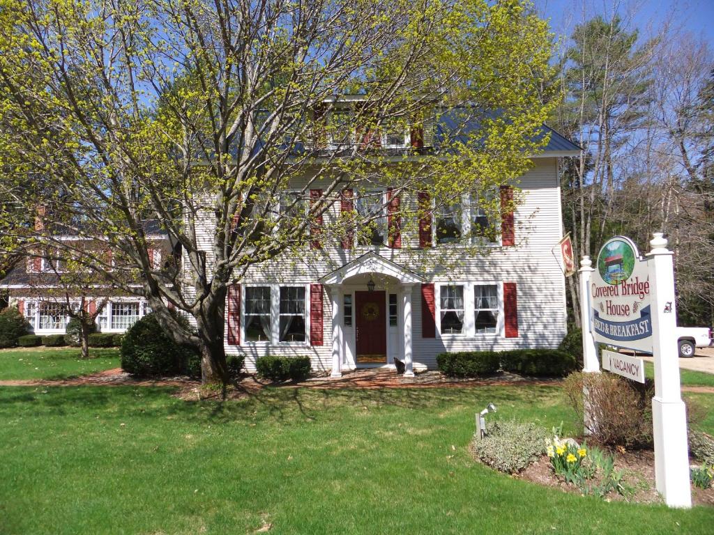 a white house with a sign in front of it at Covered Bridge House in Glen