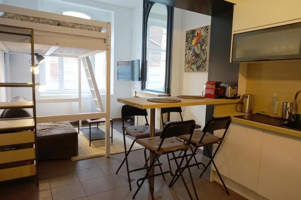 eine kleine Küche mit einem Tisch und Stühlen in einem Zimmer in der Unterkunft Cosy Appartement proche Gares #1 in Lille