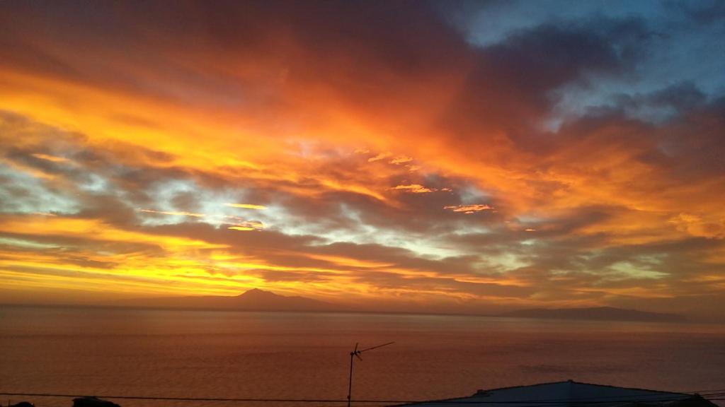 PuntallanaにあるVistas para el relaxの曇り空と海上の夕日