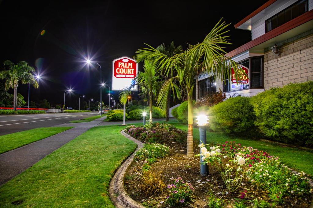 a sign for an inn on a street at night at BKs Palm Court Motor Lodge in Gisborne