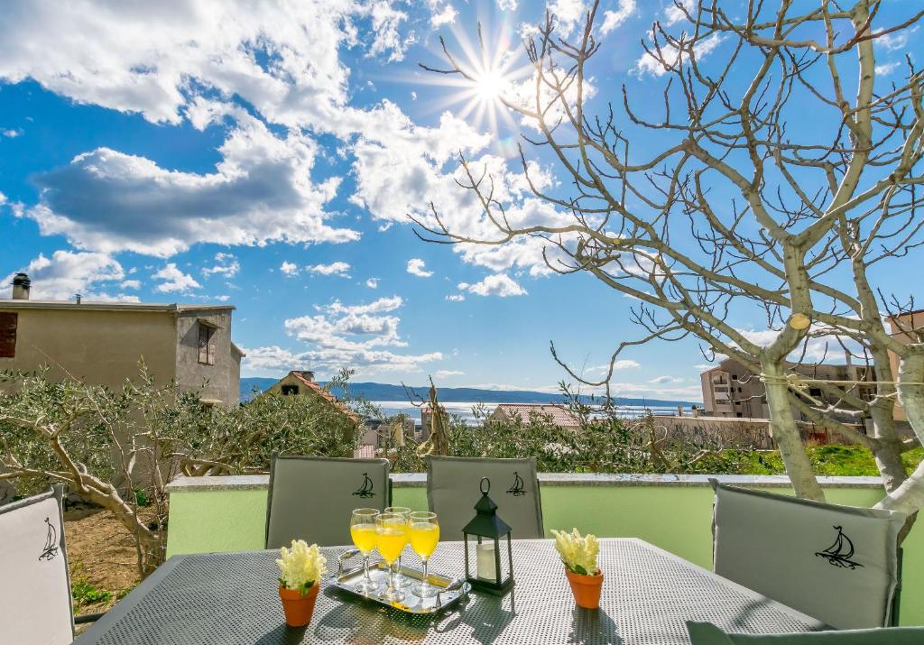 a table with drinks on a balcony with a view at Apartment Ivano in Dugi Rat