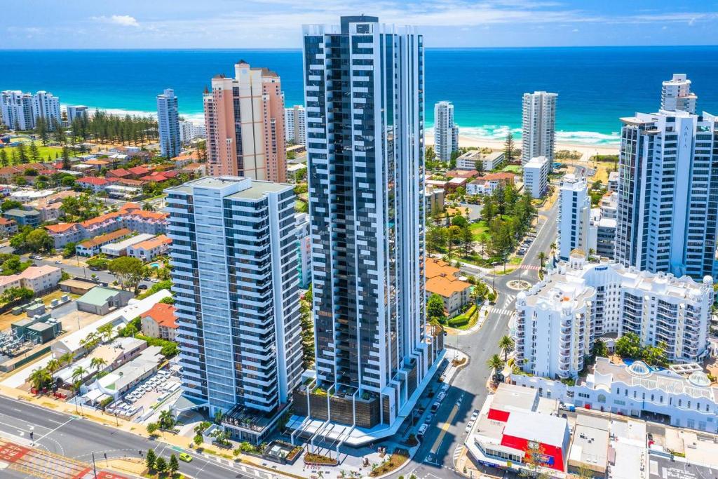 eine Luftansicht auf eine Stadt mit hohen Gebäuden und dem Meer in der Unterkunft Qube Broadbeach Ocean View Apartments in Gold Coast