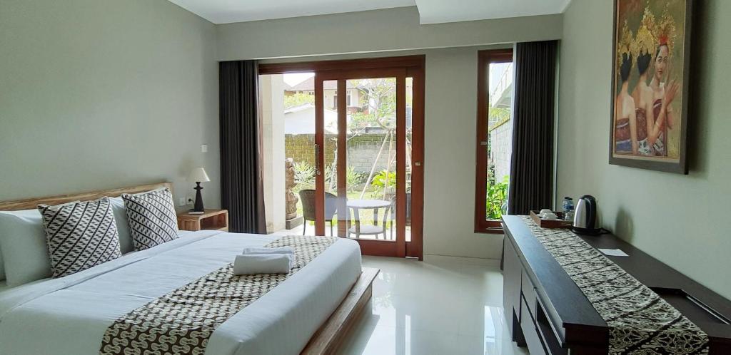 una camera con un grande letto e un balcone di Kyumari ad Ubud