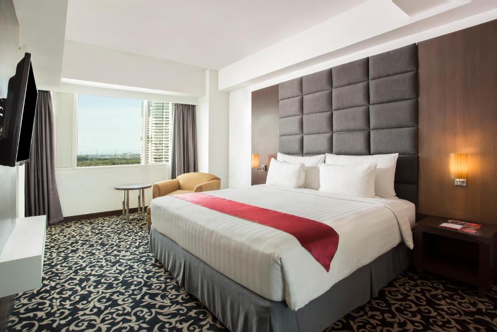 Postel nebo postele na pokoji v ubytování Swiss-Belinn Kemayoran