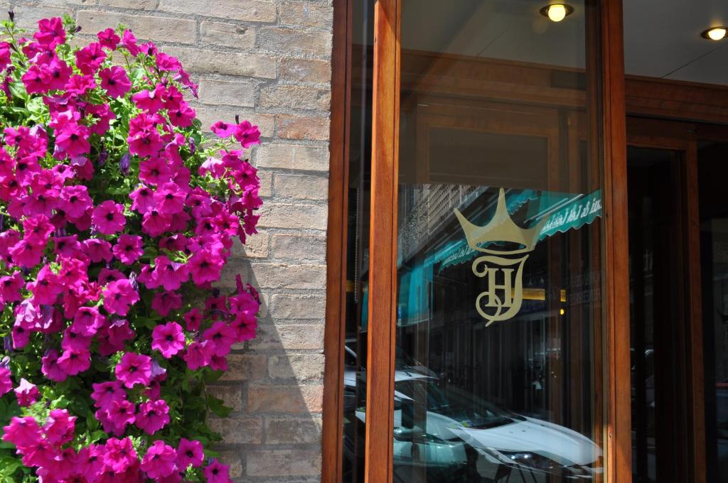 een reflectie van een auto in een raam met paarse bloemen bij Hotel Igea in Padua