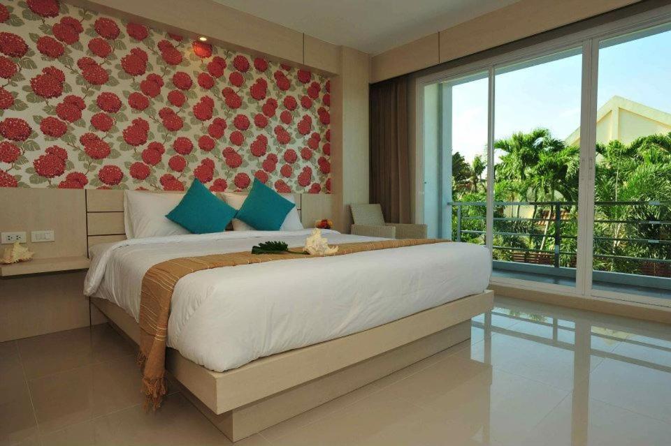 1 dormitorio con cama grande y ventana grande en Chalong Beach Front Residence, en Rawai Beach