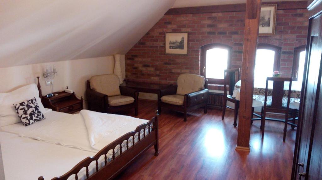 een woonkamer met een bed en een tafel en stoelen bij Apartments U Kašny in Kadaň