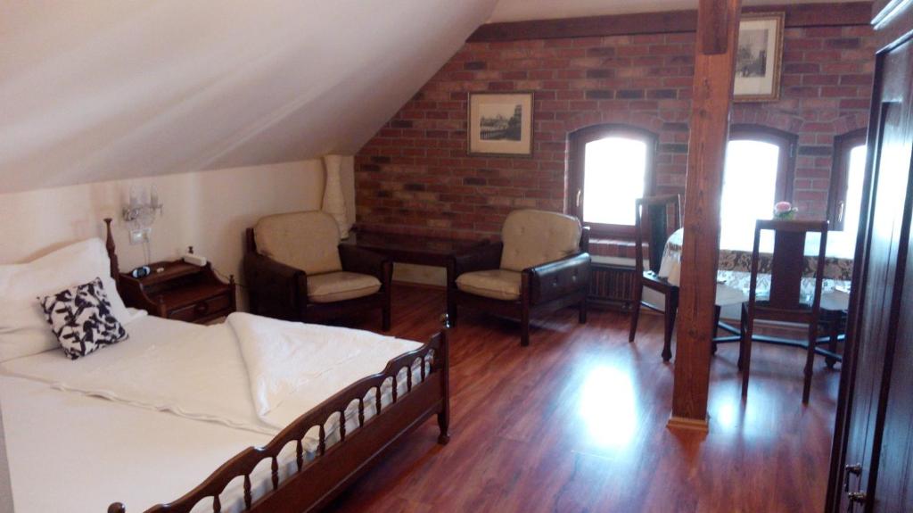 salon z łóżkiem, stołem i krzesłami w obiekcie Apartments U Kašny w mieście Kadaň