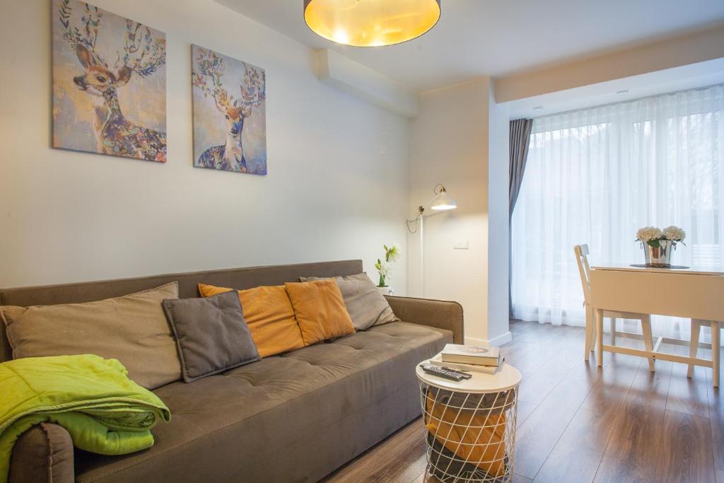 ein Wohnzimmer mit einem Sofa und einem Tisch in der Unterkunft Dubingių apartamentai Nr. 2 in Vilnius