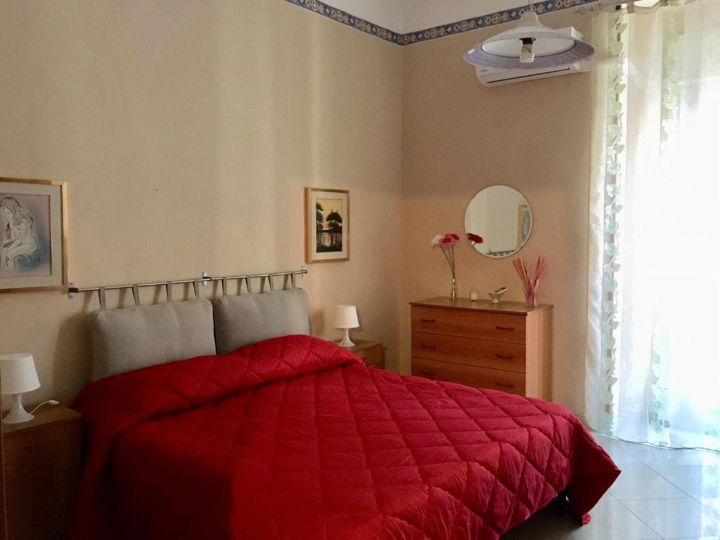 カターニアにあるFlat for 2 in Catania, with new air conditioning system 2023, B&B Le voci del mercatoのベッドルーム(赤いベッド1台、鏡付)