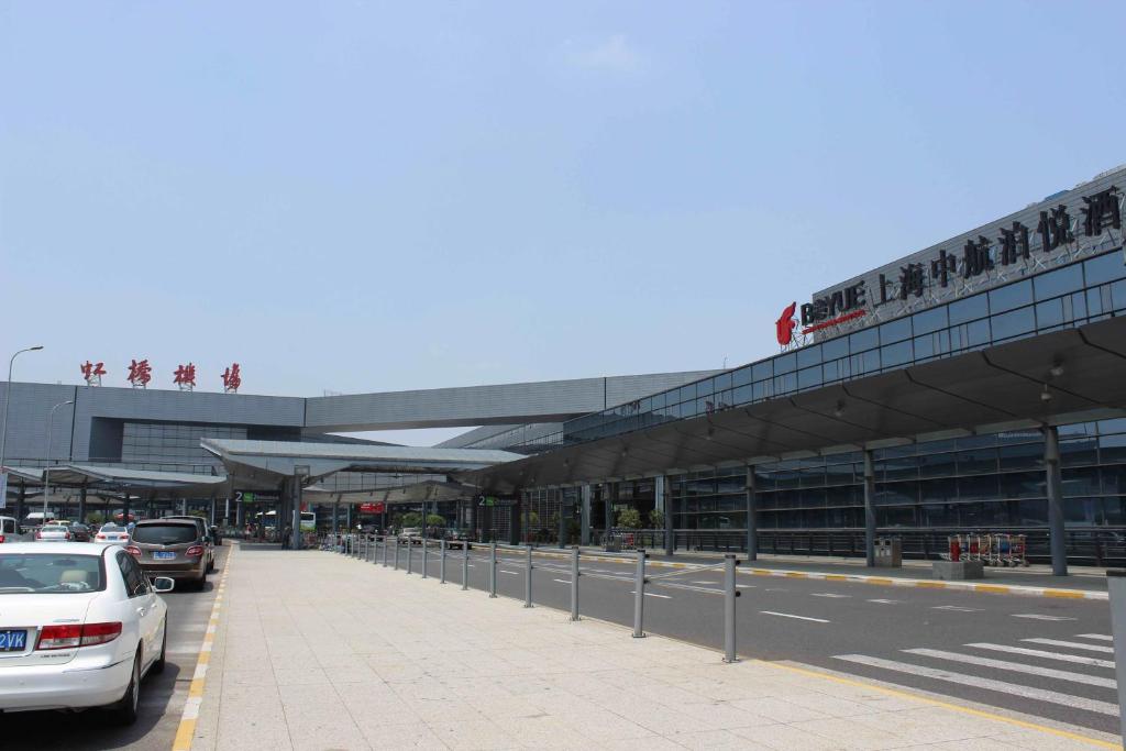 a parking lot with cars parked in front of a building at Shanghai Hongqiao Airport Hotel - Air China in Shanghai