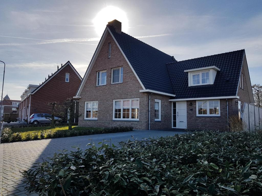a brick house with a black roof at Vakantiewoning aan Zee in Zoutelande