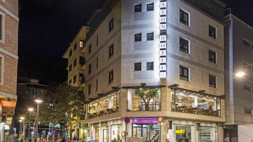 un bâtiment avec un panneau sur son côté la nuit dans l'établissement Aston Hotel, à Andorre-la-Vieille