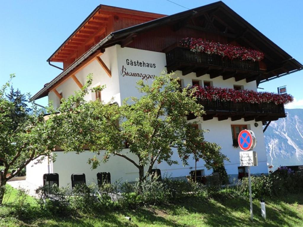 a building with a bunch of flowers on the balcony at Gästehaus Braunegger in Oetz