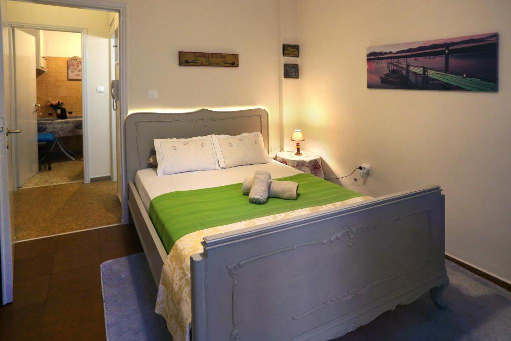 un letto con una coperta verde e due cuscini sopra di Aristotle's studio apartment ad Atene