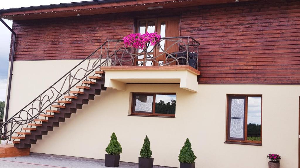 a house with a staircase on the side of it at Irmos Apartamentai salia Klaipedos in Toleikiai