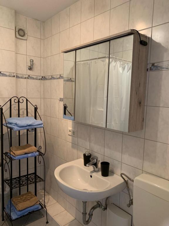 ein Badezimmer mit einem Waschbecken, einem Spiegel und einem WC in der Unterkunft Modernes 2 Zimmer Appartment in Göttingen