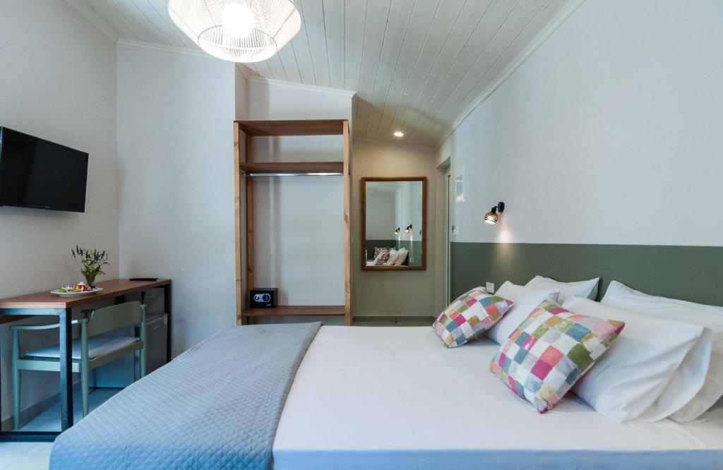 Schlafzimmer mit einem Bett, einem Schreibtisch und einem TV in der Unterkunft Mimoza Beach in Argassi