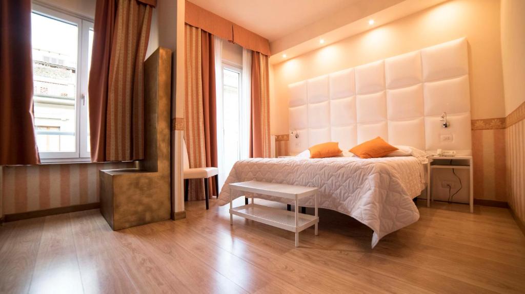 um quarto com uma cama, uma mesa e uma janela em Hotel Jane em Florença