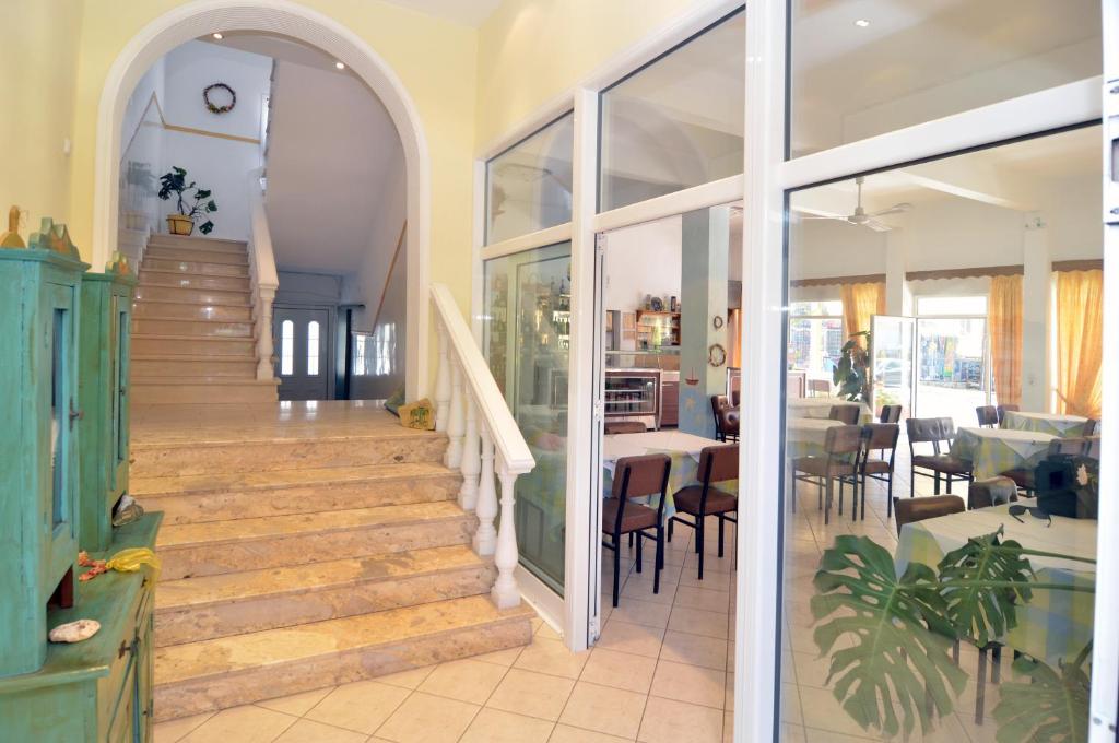 a staircase in a house with a table and chairs at Polizotou Rooms in Skala Sotiros