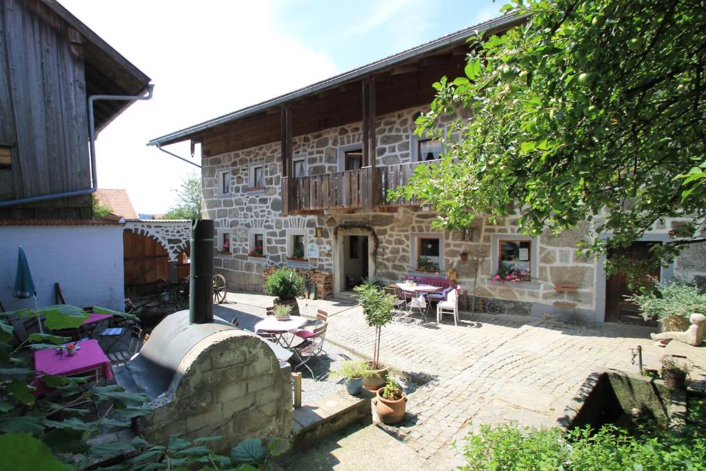 ein Steingebäude mit einem Innenhof und einer Terrasse in der Unterkunft Landurlaub bei Familie Haug in Freyung