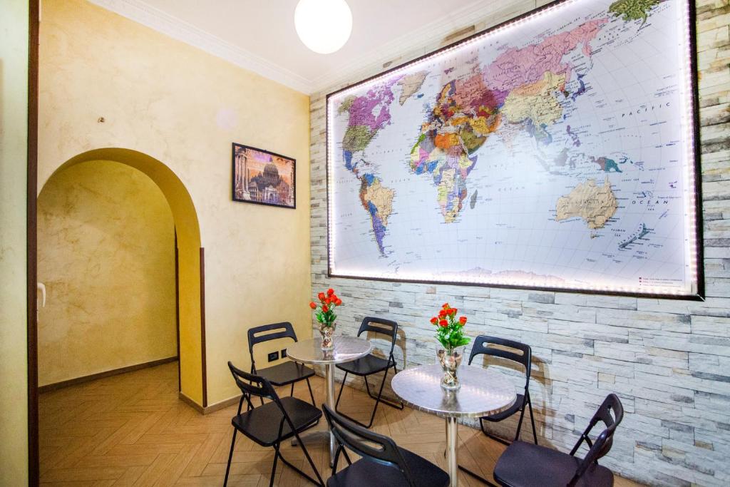 una stanza con due tavoli e sedie con una mappa sul muro di Funny Palace Hostel a Roma