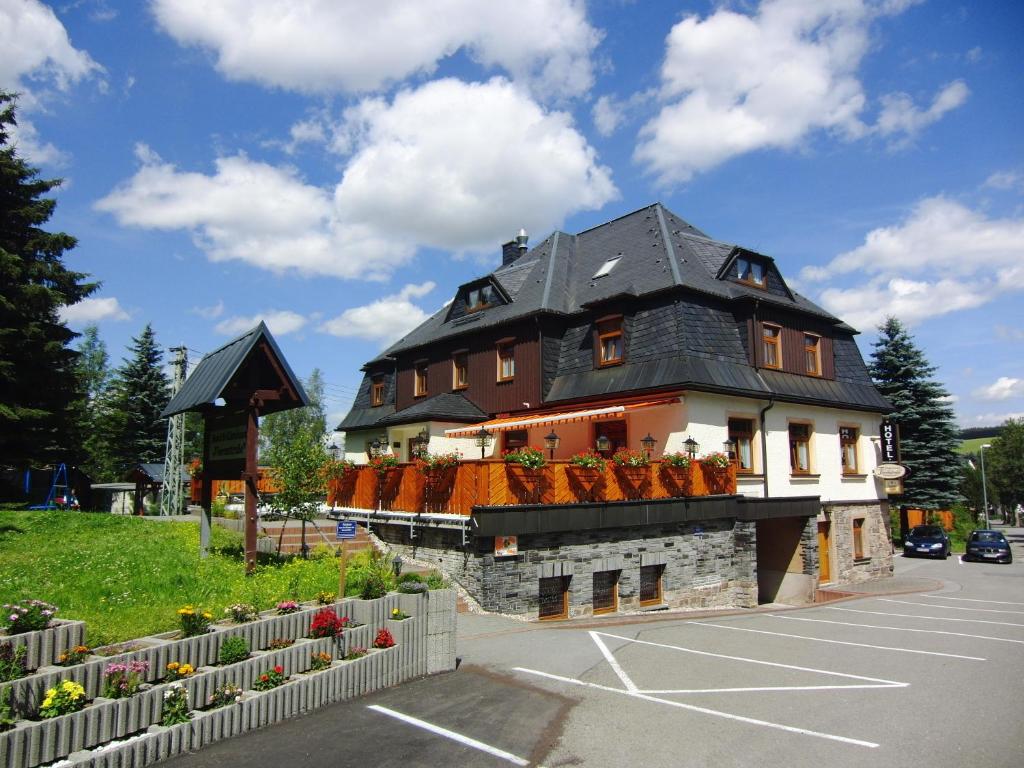 a large house with a black roof on a parking lot at Hotel Vierenstraße in Neudorf