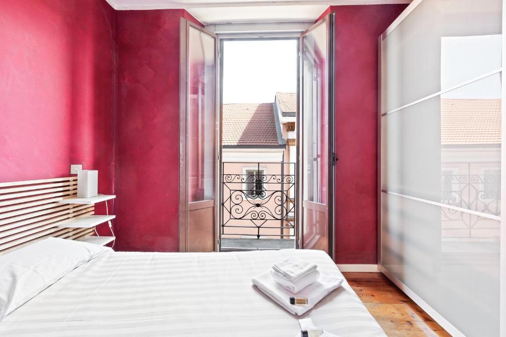 ein Schlafzimmer mit einem weißen Bett und einer roten Wand in der Unterkunft Buenos Aires Shopping Flat in Mailand