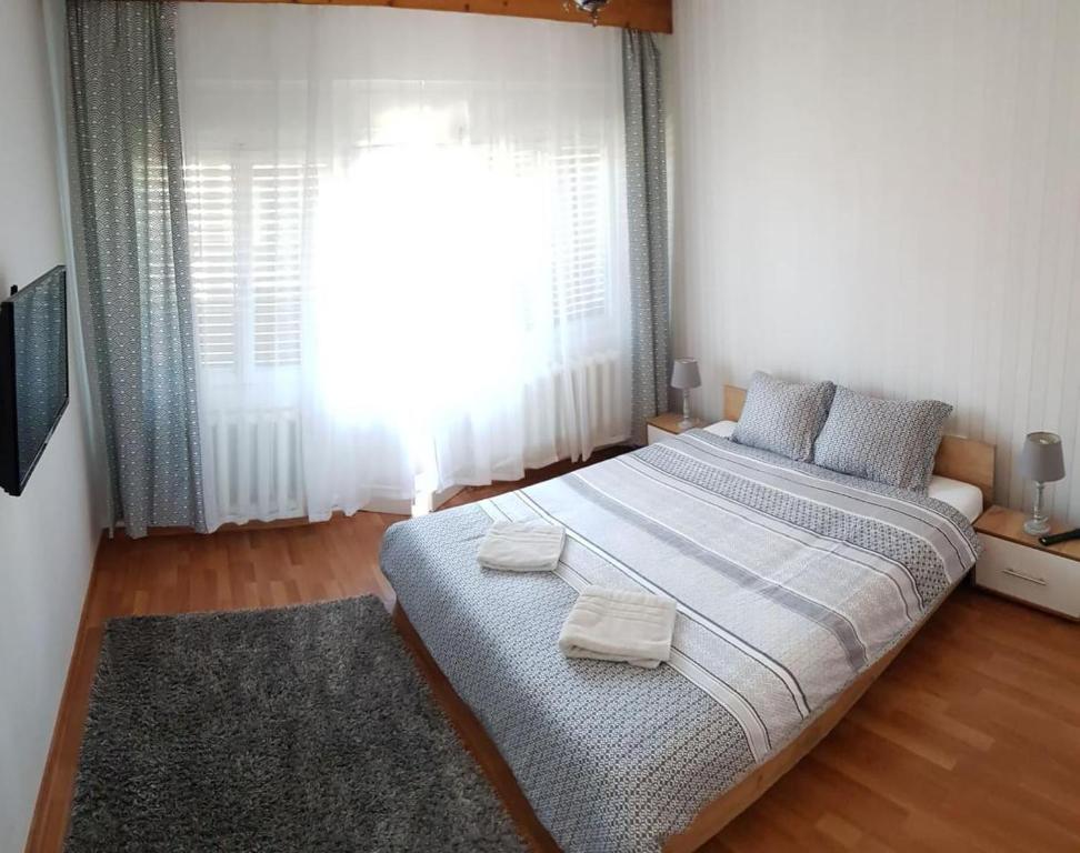 a bedroom with a large bed with two towels on it at Premium Central Apartment in Oradea