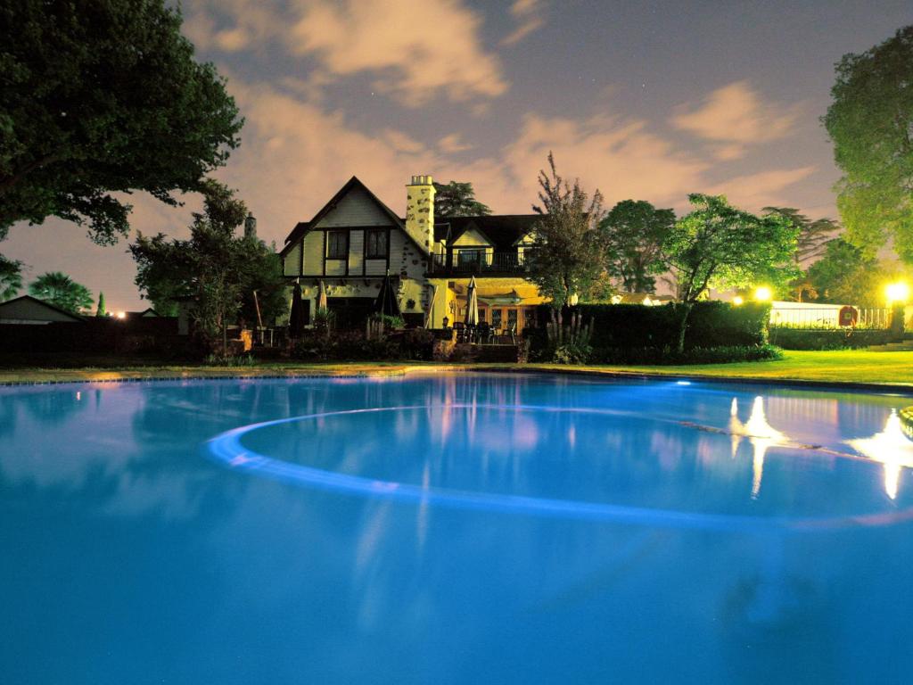 a large blue swimming pool in front of a house at Lauriston Guesthouse in Centurion