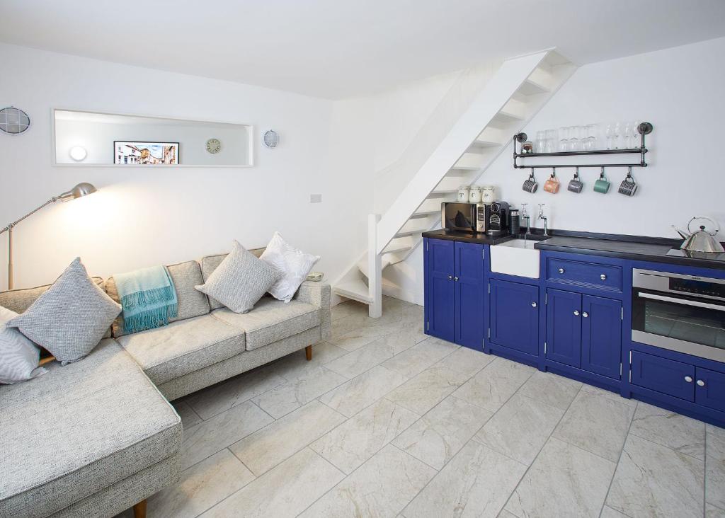 a living room with blue cabinets and a couch at Host & Stay - Harbour Cottage in Staithes