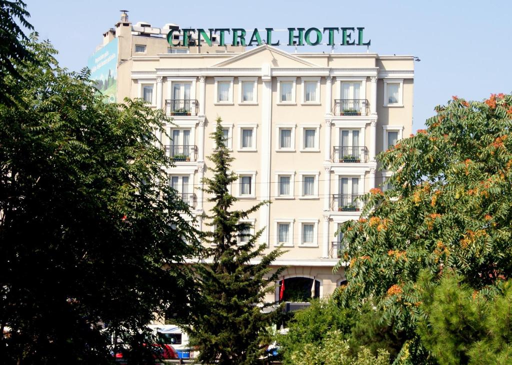 Un bâtiment blanc avec un panneau en haut dans l'établissement Central Hotel, à Bursa