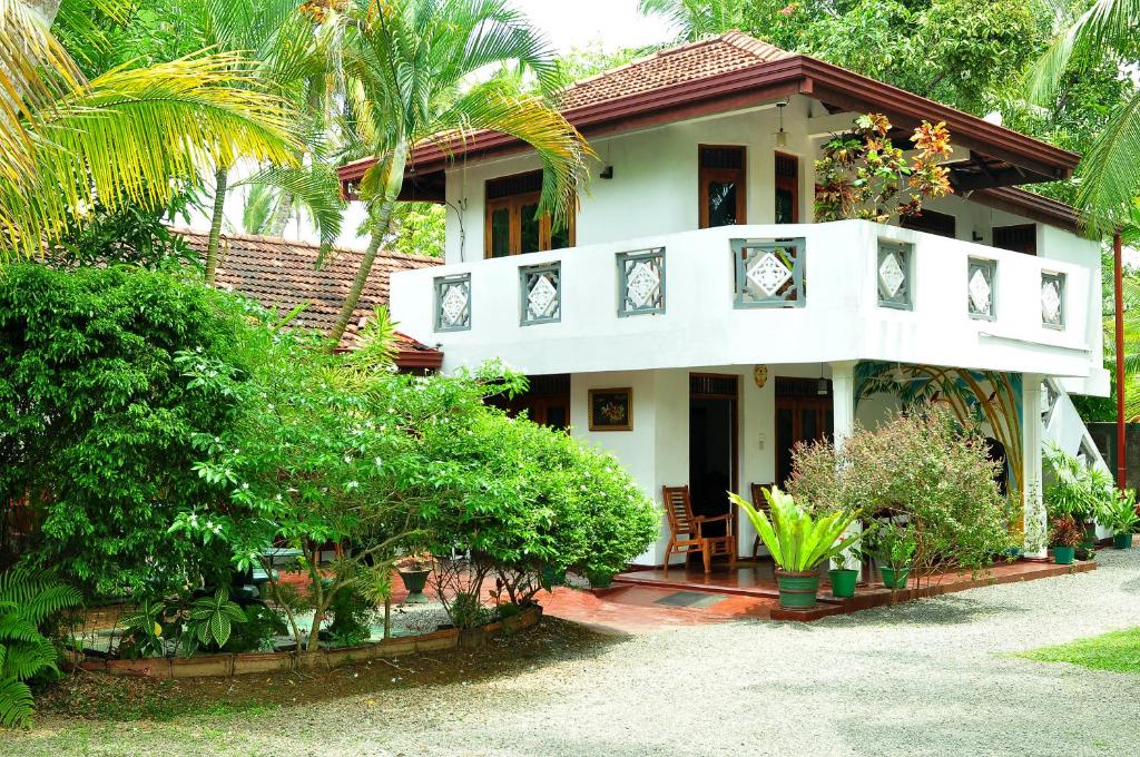une maison blanche avec des arbres et des plantes dans l'établissement Solal Villa, à Aluthgama