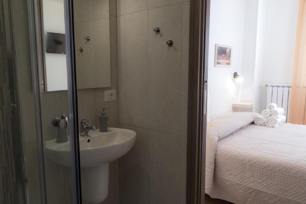 a small bathroom with a sink and a bed at Coco'S Rooms in Bari Palese