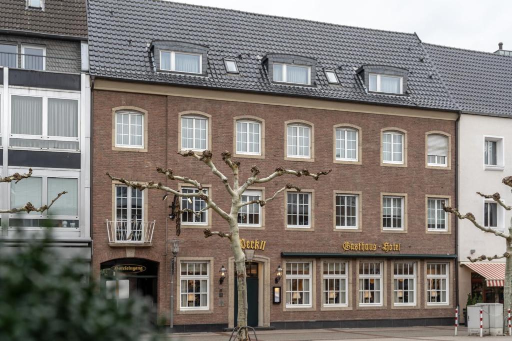 un edificio de ladrillo con un árbol delante de él en Hotel Werk II, en Bocholt