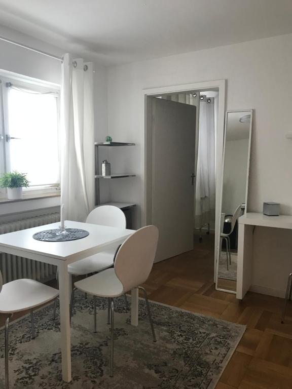 a white dining room with a table and chairs at Small Home in Freudenstadt