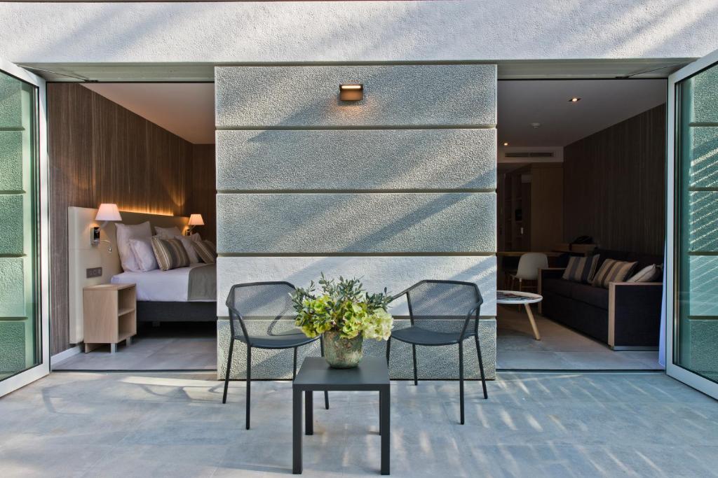 a hotel room with two chairs and a bed at Golden Tulip Sophia Antipolis - Hotel &amp; Spa in Valbonne